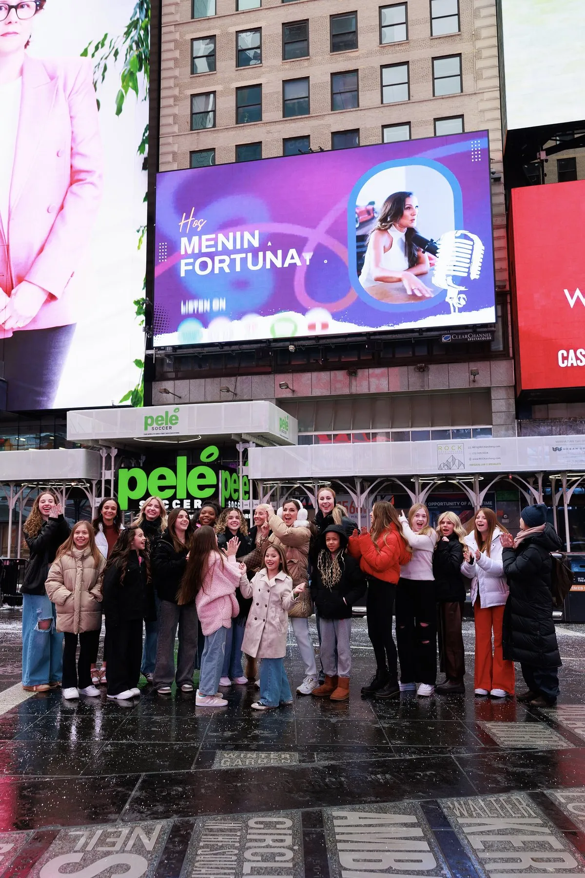 The Business of Dance on a Times Square billboard, with Fortunato and her dancers below it, February 2025.